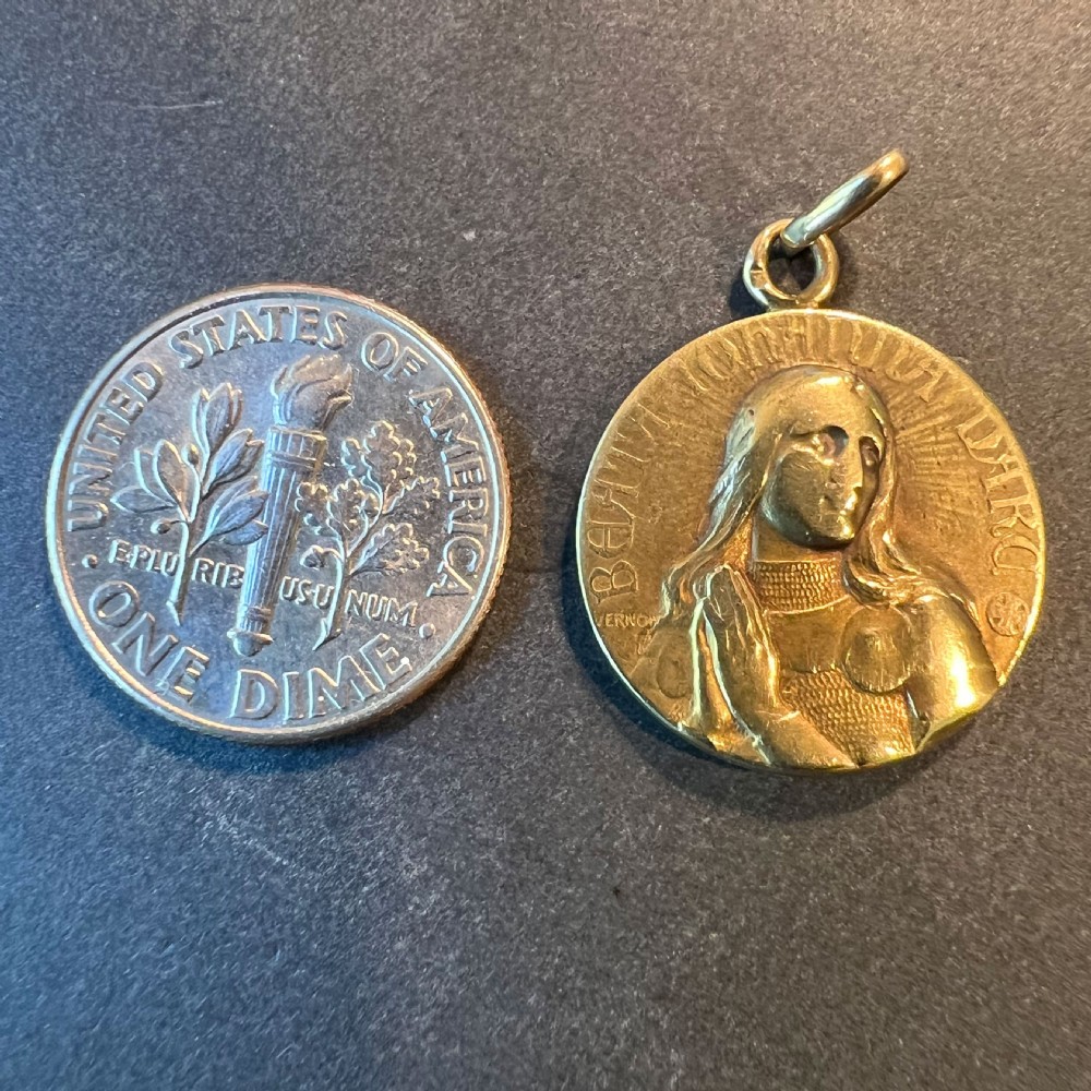 A circular 18K yellow gold devotional medal featuring a relief profile portrait of Saint Joan of Arc. View XI