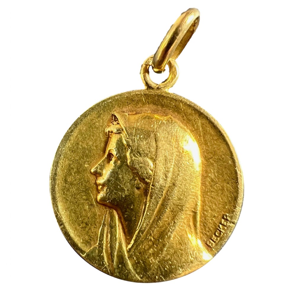 A circular 18ct yellow gold religious medal featuring a bas-relief profile portrait of the Virgin Mary, signed by the artist Becker.