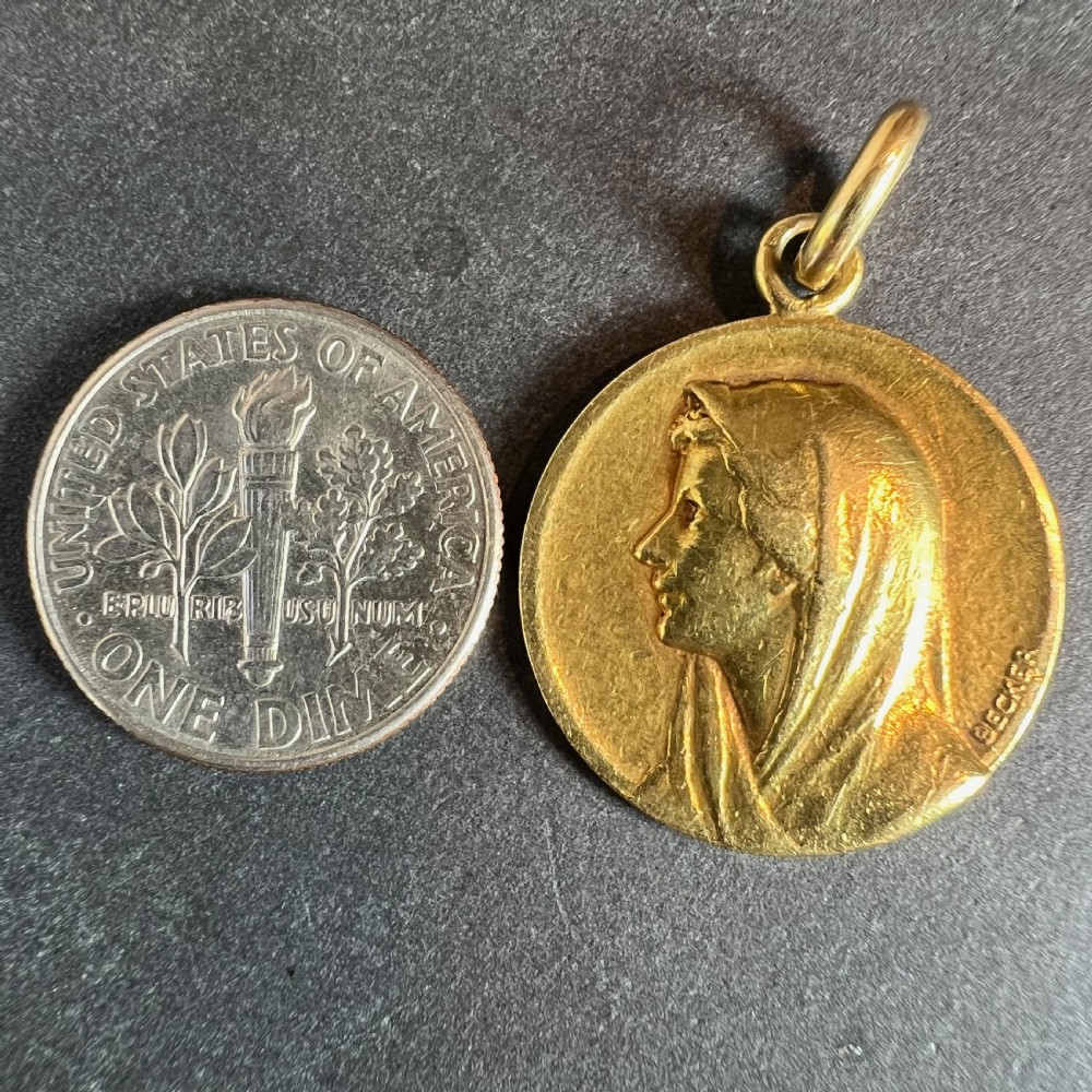 A circular 18ct yellow gold religious medal featuring a bas-relief profile portrait of the Virgin Mary, signed by the artist Becker. View XI
