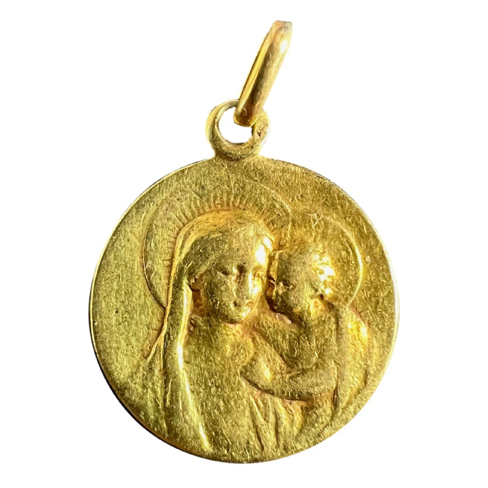A circular 18-carat yellow gold religious medal pendant depicting the relief profile of the Madonna and Child.