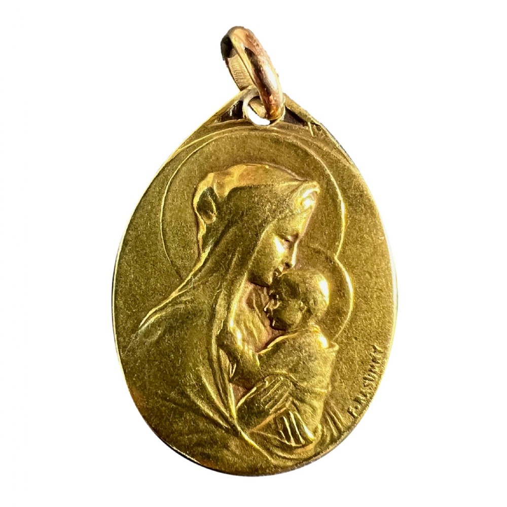 An oval 18-carat yellow gold antique religious medal featuring a bas-relief depiction of the Madonna and Child in profile, signed Rasumny.