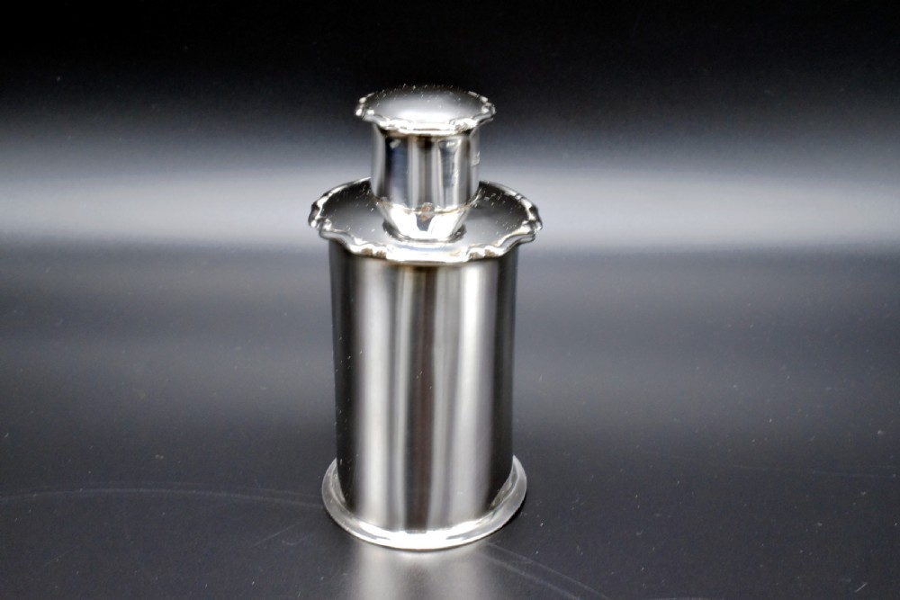 A cylindrical Edwardian sterling silver tea caddy with a scalloped edge lid and an engraved monogram on the front. View II