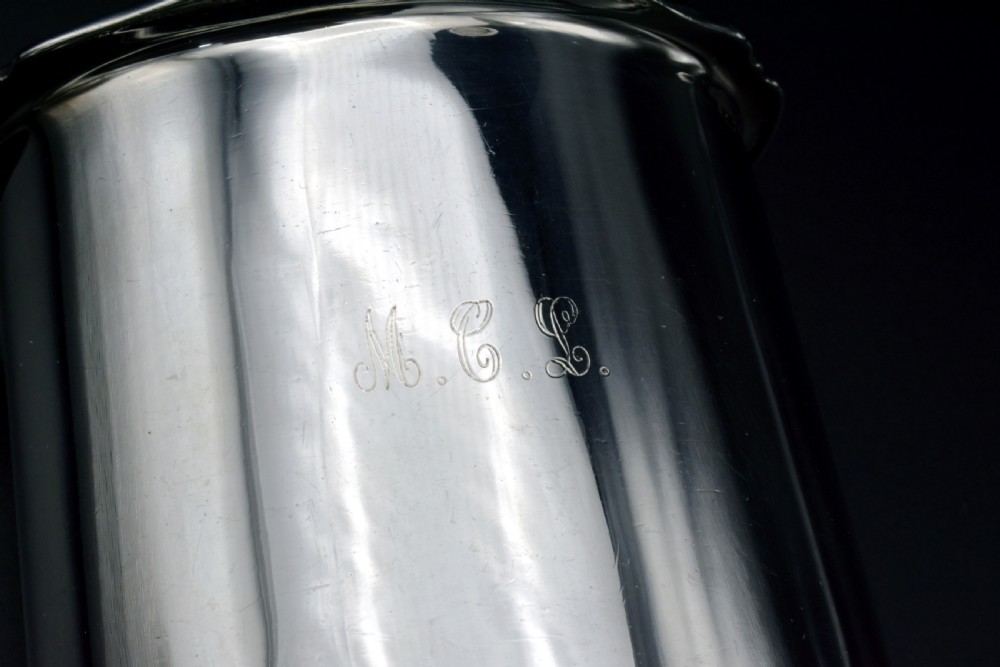 A cylindrical Edwardian sterling silver tea caddy with a scalloped edge lid and an engraved monogram on the front. View V