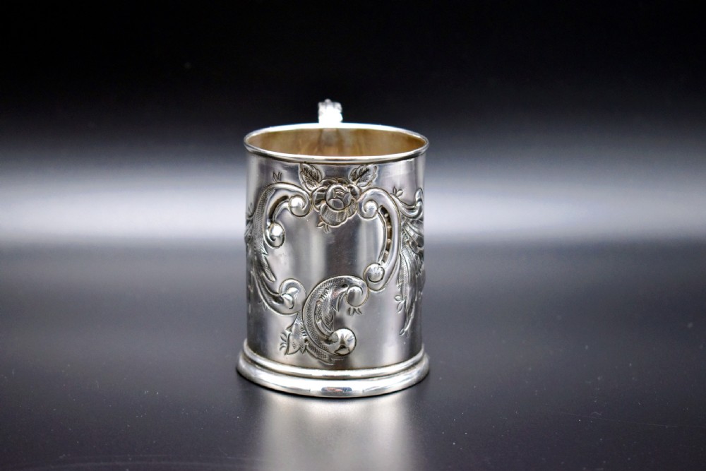 A late Victorian sterling silver tankard featuring etched floral motifs and British hallmarks near the top rim. View VI