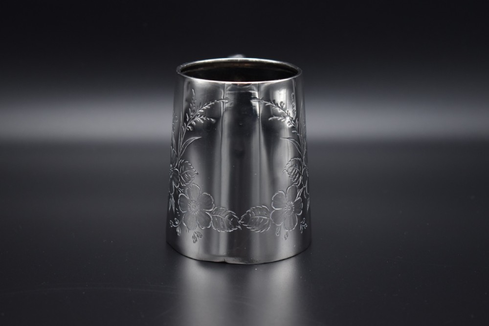 A late Victorian sterling silver tankard featuring etched floral motifs and British hallmarks near the top rim. View X