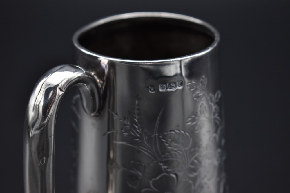 A late Victorian sterling silver tankard featuring etched floral motifs and British hallmarks near the top rim. View XIV