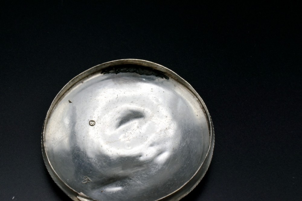 A circular 19th-century Dutch sterling silver snuff box featuring concentric engine-turned engraving and reeded borders. View V