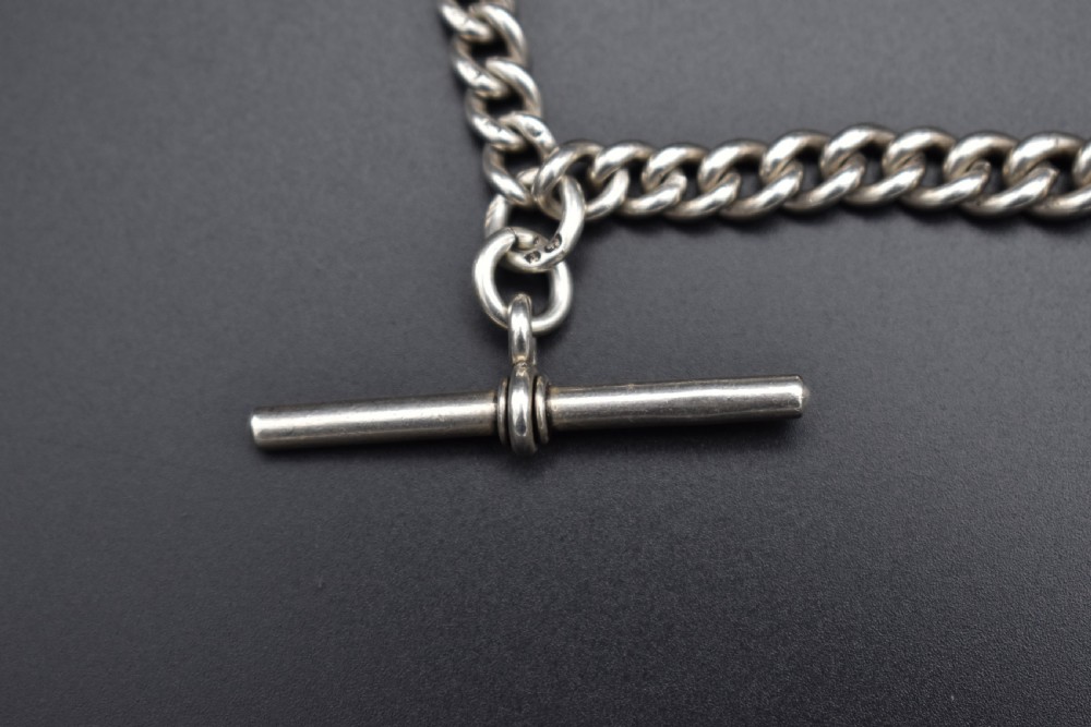 A Victorian sterling silver Albert watch chain featuring heavy curb links, a T-bar fastener, and a swivel clasp. View II