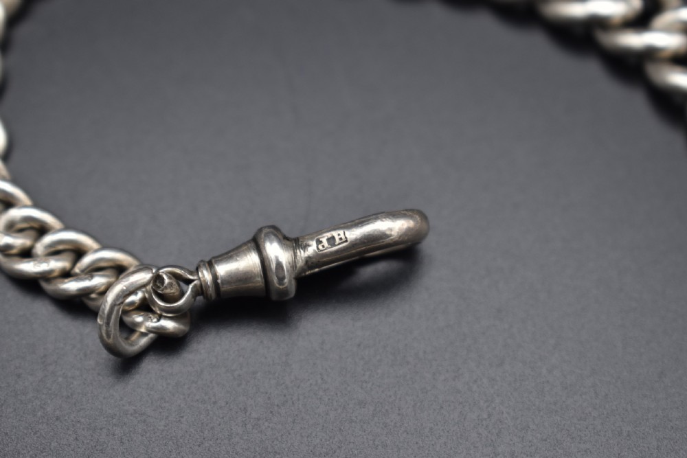 A Victorian sterling silver Albert watch chain featuring heavy curb links, a T-bar fastener, and a swivel clasp. View IV