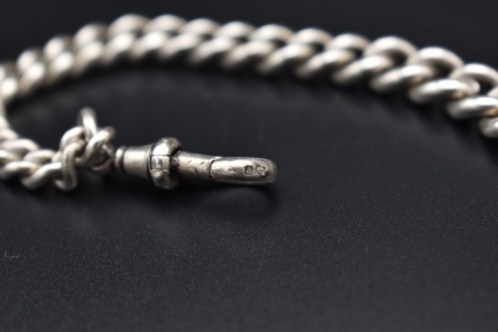 A Victorian sterling silver Albert watch chain featuring heavy curb links, a T-bar fastener, and a swivel clasp. View V