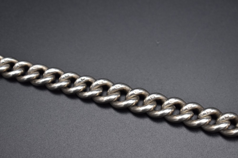 A Victorian sterling silver Albert watch chain featuring heavy curb links, a T-bar fastener, and a swivel clasp. View IX