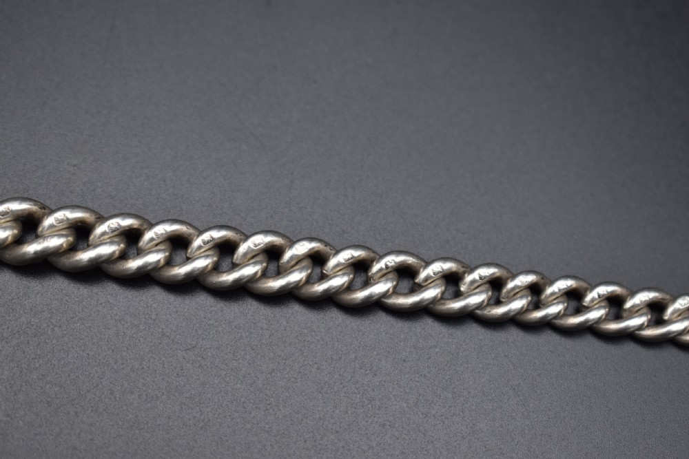 A Victorian sterling silver Albert watch chain featuring heavy curb links, a T-bar fastener, and a swivel clasp. View X