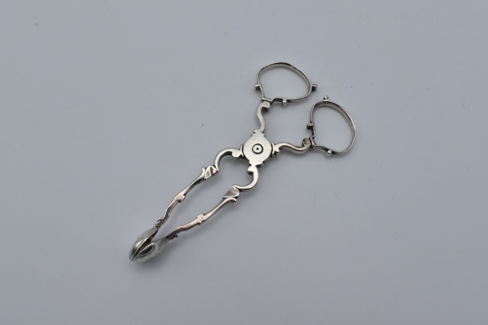 An 18th-century Georgian sterling silver scissor-form sugar nip with curved scroll handles and shell-shaped grips. View II
