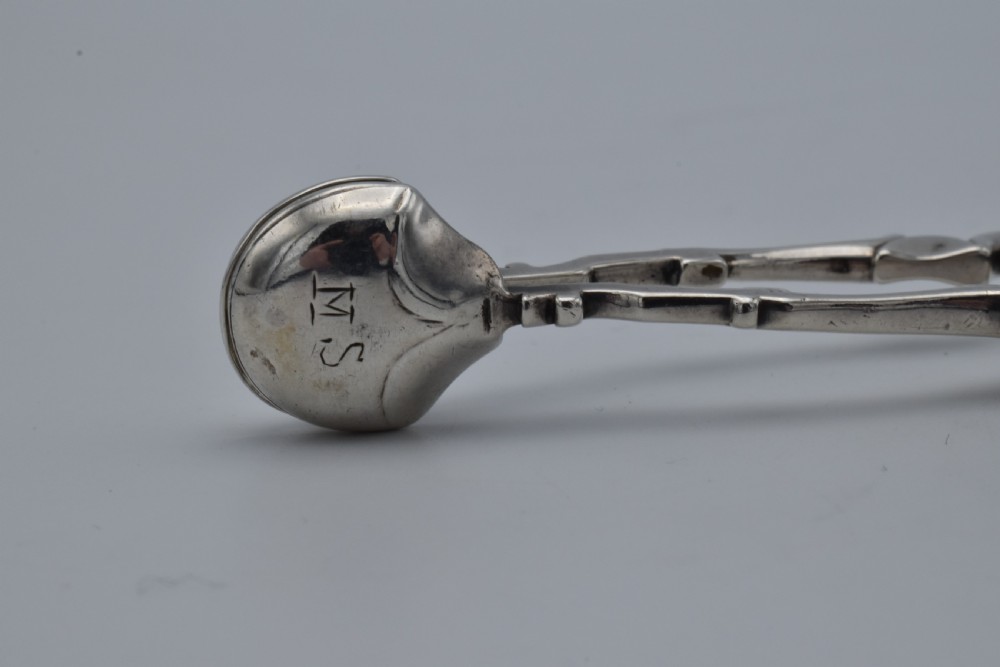 An 18th-century Georgian sterling silver scissor-form sugar nip with curved scroll handles and shell-shaped grips. View IV