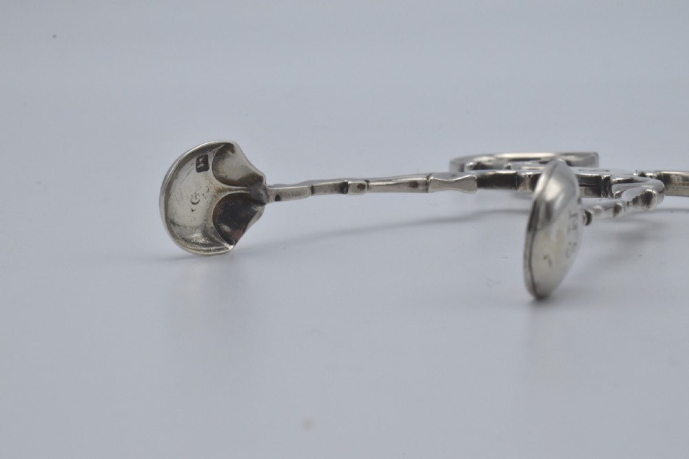 An 18th-century Georgian sterling silver scissor-form sugar nip with curved scroll handles and shell-shaped grips. View V
