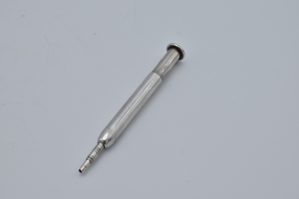 A Victorian sterling silver pocket notebook featuring a hammered finish, central monogram cartouche, top suspensory ring, and British hallmarks dated 1899. View XI