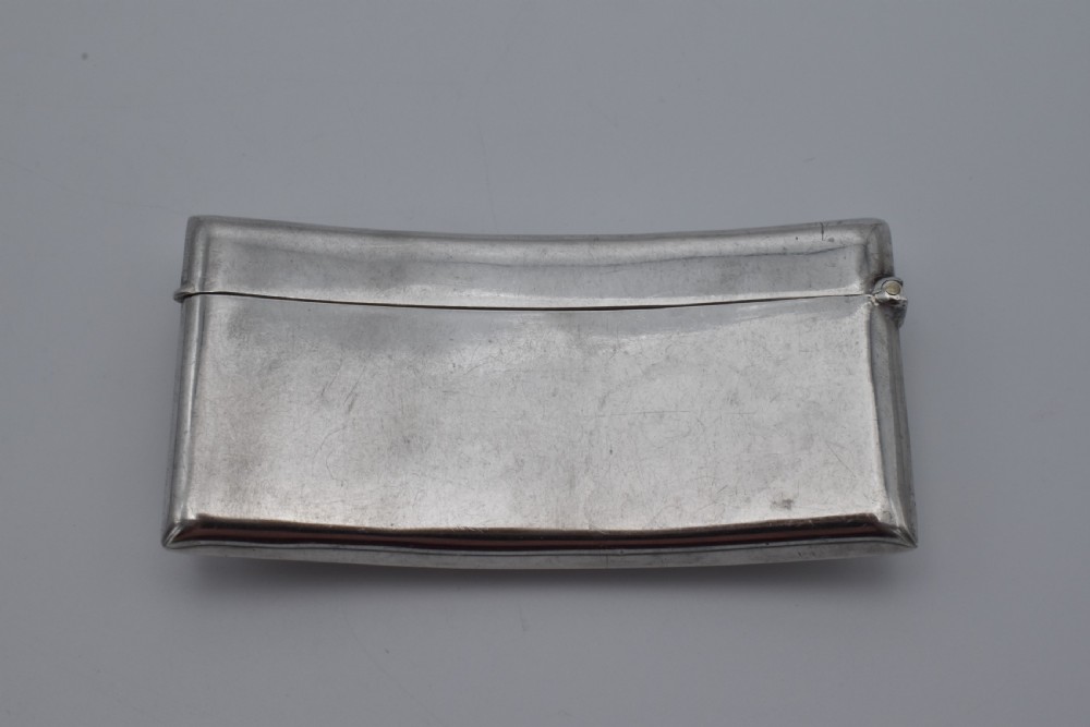 A curved sterling silver card case with hand-engraved monogram initials and visible British hallmarks near the top hinge. View II