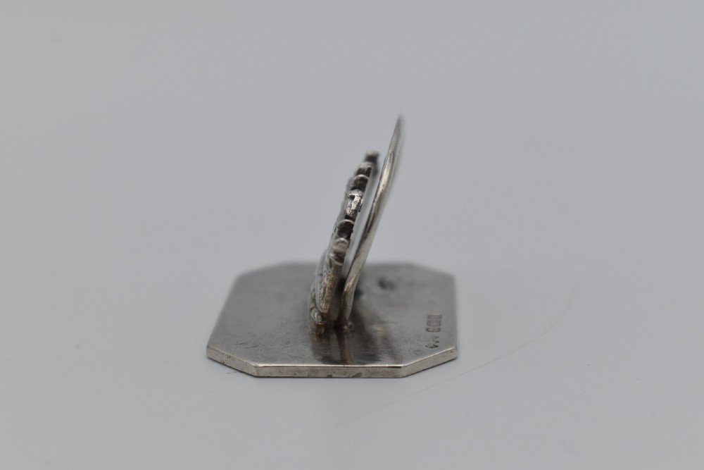 A sterling silver menu holder shaped like a naval crown mounted on an octagonal silver base. View II