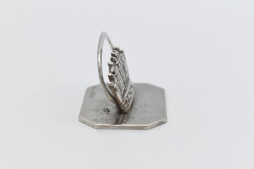 A sterling silver menu holder shaped like a naval crown mounted on an octagonal silver base. View IV
