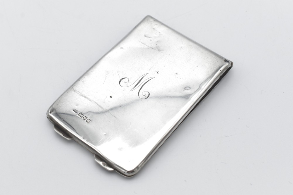 A rectangular sterling silver aide-memoire card case featuring a central hand-engraved cursive monogram M and hallmarks on the lower left corner.