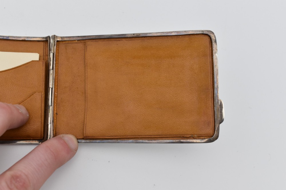 A rectangular sterling silver aide-memoire card case featuring a central hand-engraved cursive monogram M and hallmarks on the lower left corner. View VII