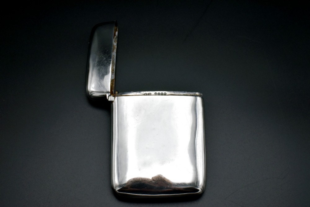 A polished Victorian sterling silver pocket card case with a hinged lid displayed on a dark background. View IV