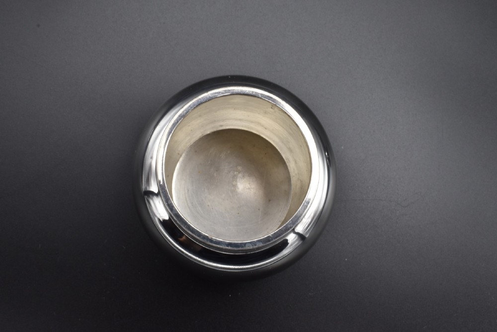 A small, bulbous sterling silver miniature tea caddy with a fitted lid, round ball finial, and visible British hallmarks stamped around the neck. View IX