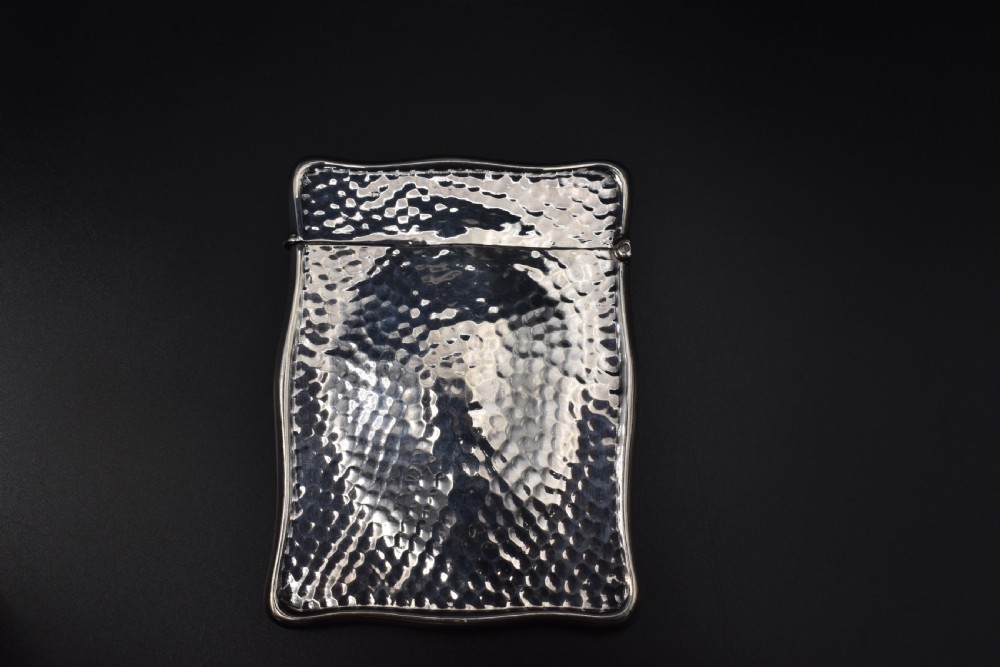 A hinged Edwardian sterling silver card case featuring a spot-hammered textured surface and a smooth circular central cartouche. View II