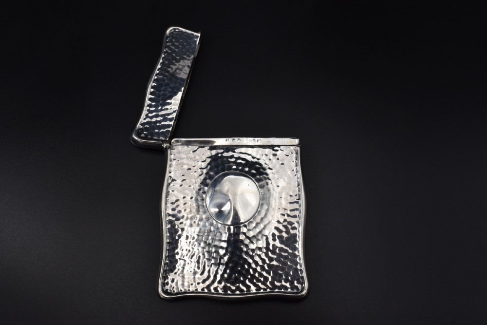 A hinged Edwardian sterling silver card case featuring a spot-hammered textured surface and a smooth circular central cartouche. View III