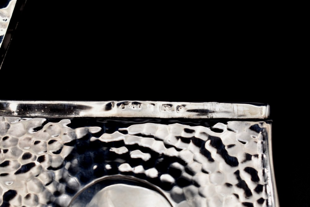 A hinged Edwardian sterling silver card case featuring a spot-hammered textured surface and a smooth circular central cartouche. View IV
