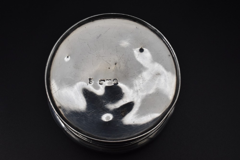 A circular Victorian sterling silver powder box featuring raised repousse scrollwork and foliage on the lid with a smooth cylindrical base. View IV