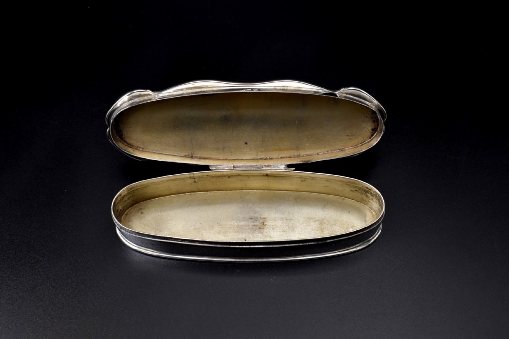 An elongated, oval Edwardian sterling silver powder box featuring engine-turned engraving on the lid and an unengraved central cartouche. View VII