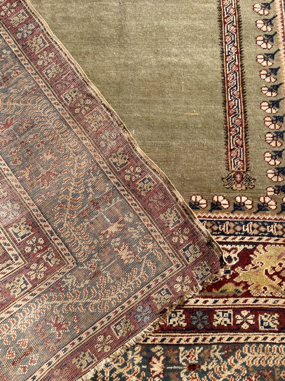 An antique hand-knotted Anatolian Ghiordes prayer rug featuring a central sage green arched niche enclosed by detailed rust red and blue decorative borders. View XIV