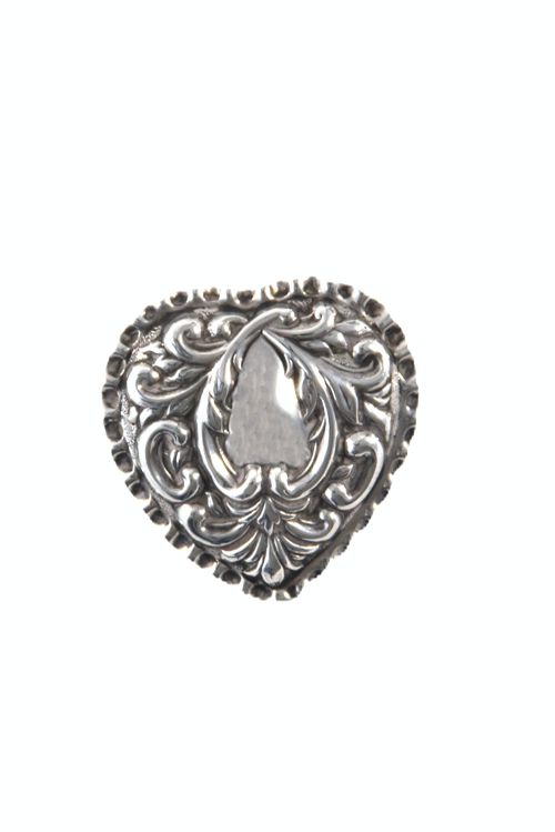 fig 2. A heart-shaped Victorian sterling silver pill box featuring elaborate repousse scrollwork on the lid, showing an open interior with gold gilding.