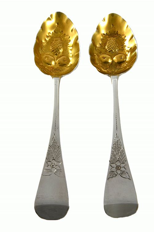 fig 1. A pair of 1810 Georgian sterling silver berry spoons featuring engraved handles and gilded, repousse bowls embossed with fruit designs.