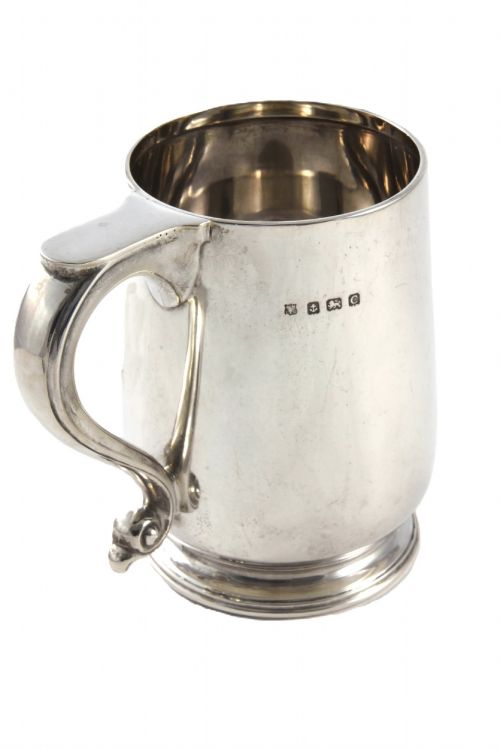 fig 1. A George V sterling silver pint tankard featuring a baluster body, engraved monogram initials, a scroll handle, and a stepped circular foot.