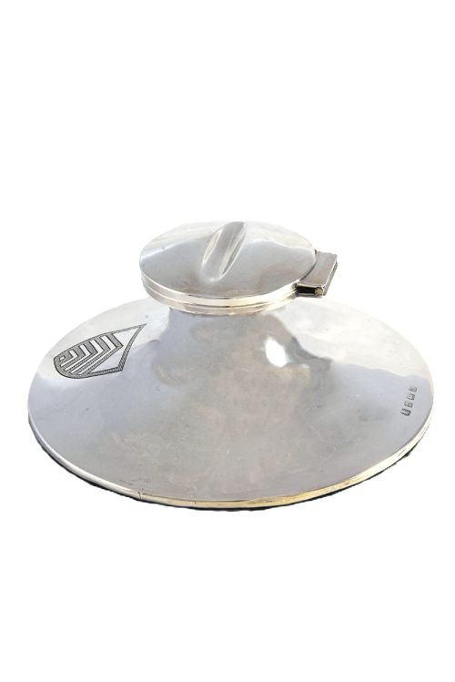 fig 2. A polished sterling silver capstan-shaped inkwell featuring a wide sloped base and an engraved crest motif.