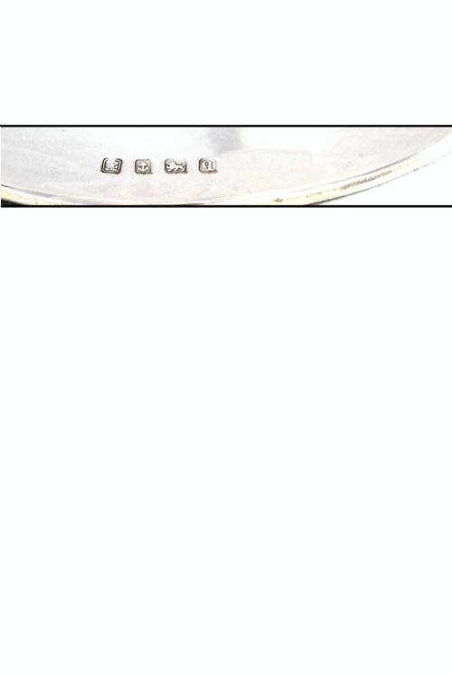 fig 4. A polished sterling silver capstan-shaped inkwell featuring a wide sloped base and an engraved crest motif.