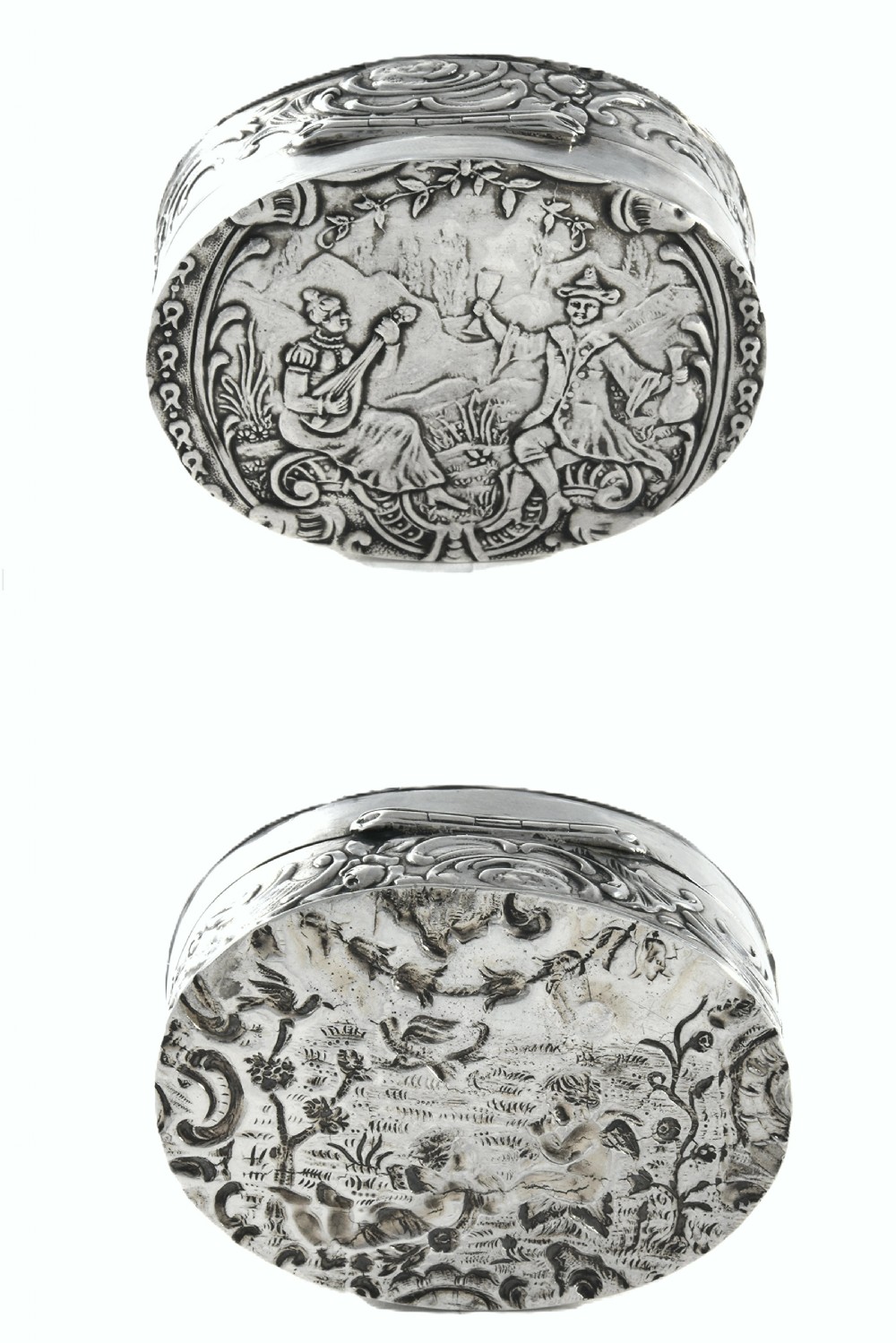 An oval Edwardian sterling silver snuff box dated 1905 featuring an embossed figural scene on the lid and scrollwork along the sides. View II