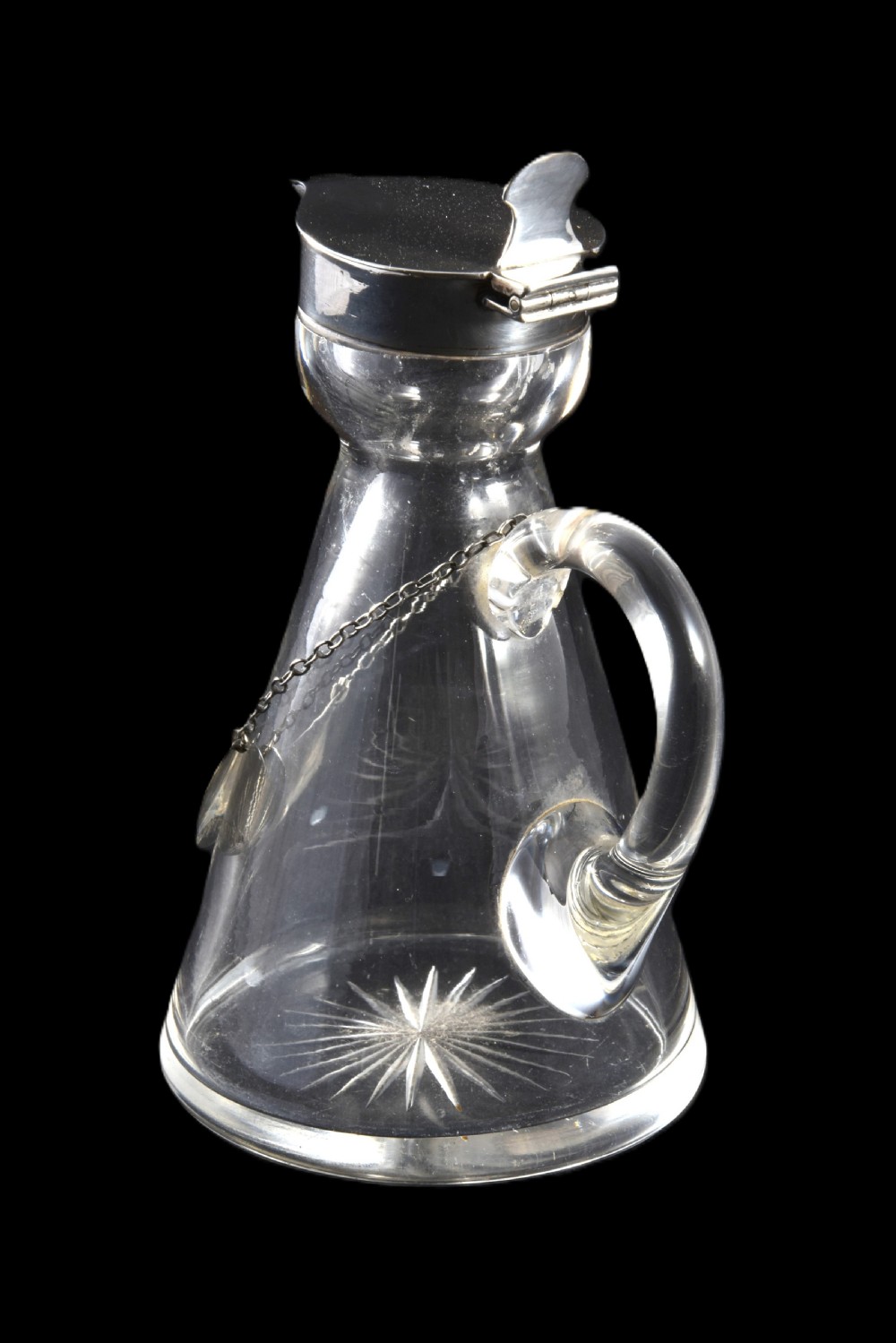 A conical clear glass whisky noggin with a starburst cut base, fitted with a silver hinged lid and an engraved silver Whisky label hanging from a chain around its neck. View III