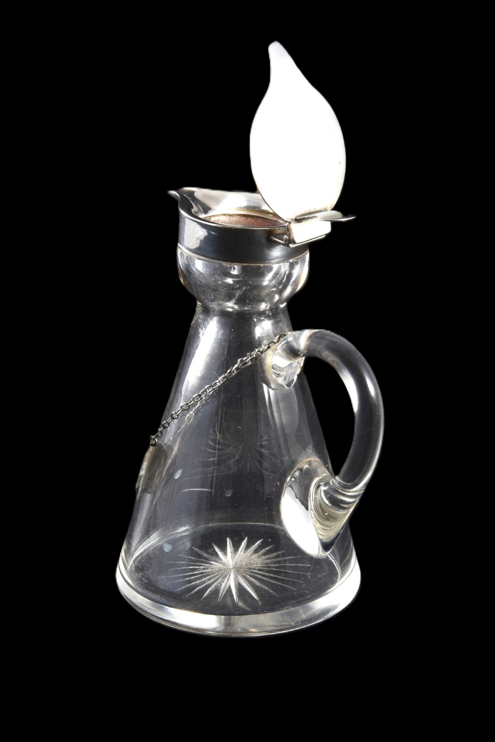 A conical clear glass whisky noggin with a starburst cut base, fitted with a silver hinged lid and an engraved silver Whisky label hanging from a chain around its neck. View IV