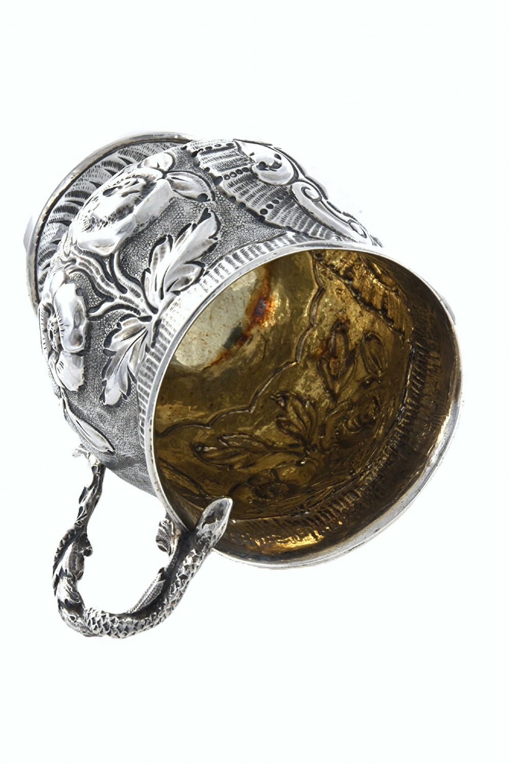 A George IV sterling silver christening mug with floral repousse work, a plain cartouche, and a curved handle set on a stepped base. View IV