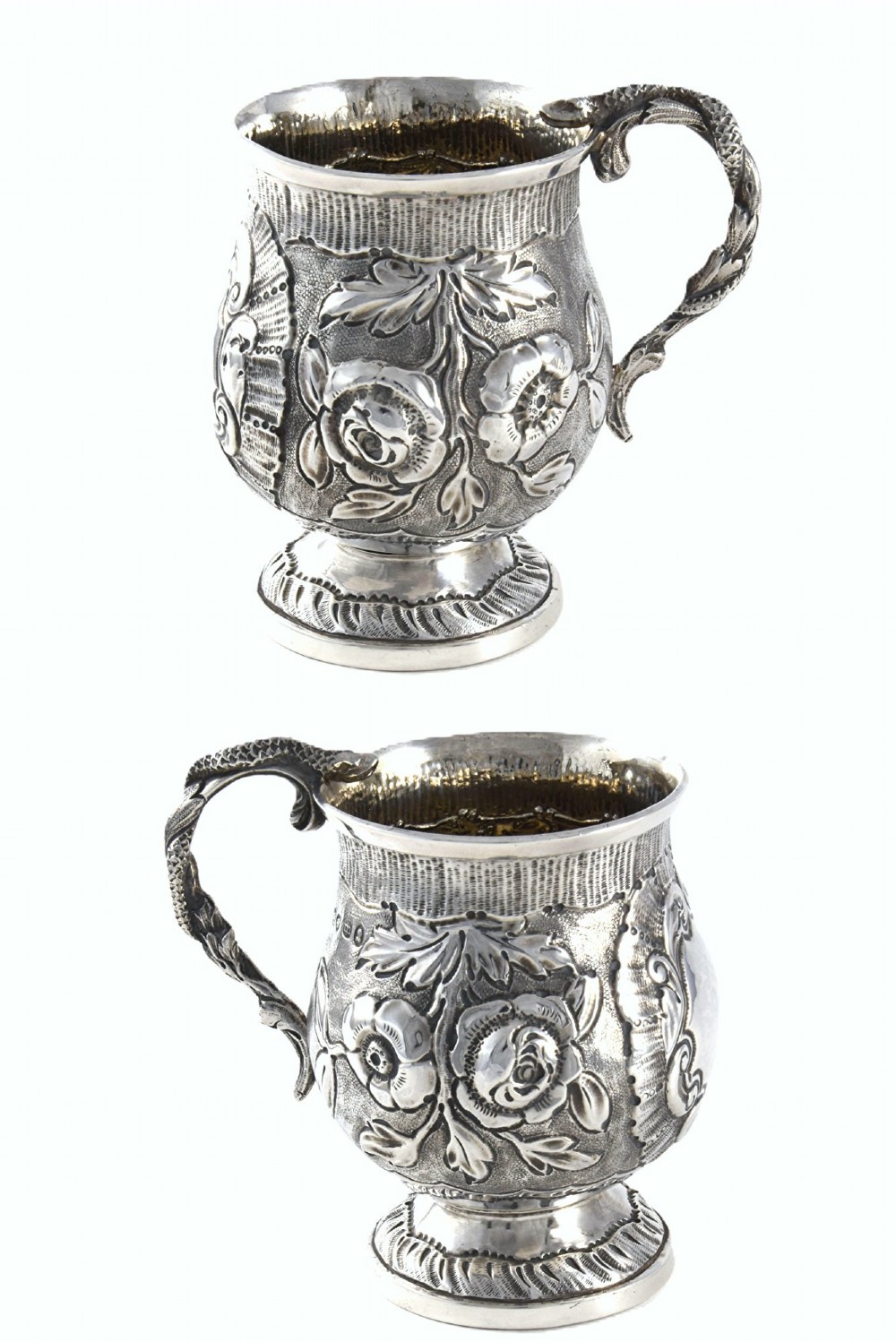 A George IV sterling silver christening mug with floral repousse work, a plain cartouche, and a curved handle set on a stepped base. View VI