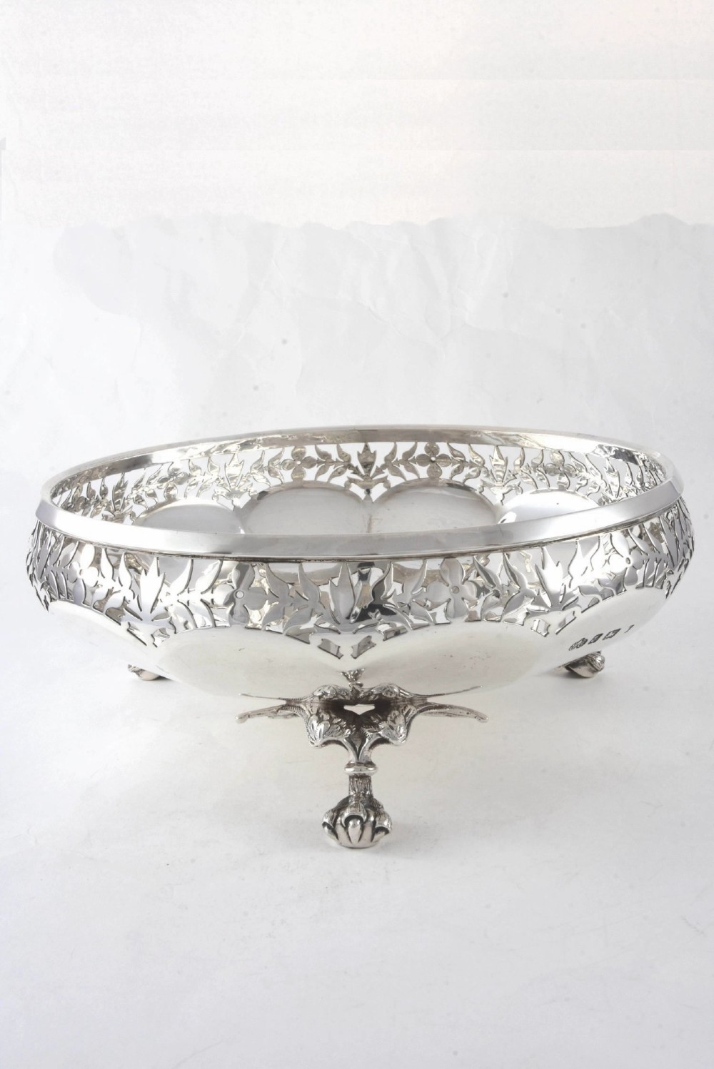 A shallow circular silver centrepiece bowl featuring intricate pierced fretwork around the border and supported by four cast claw feet. View III