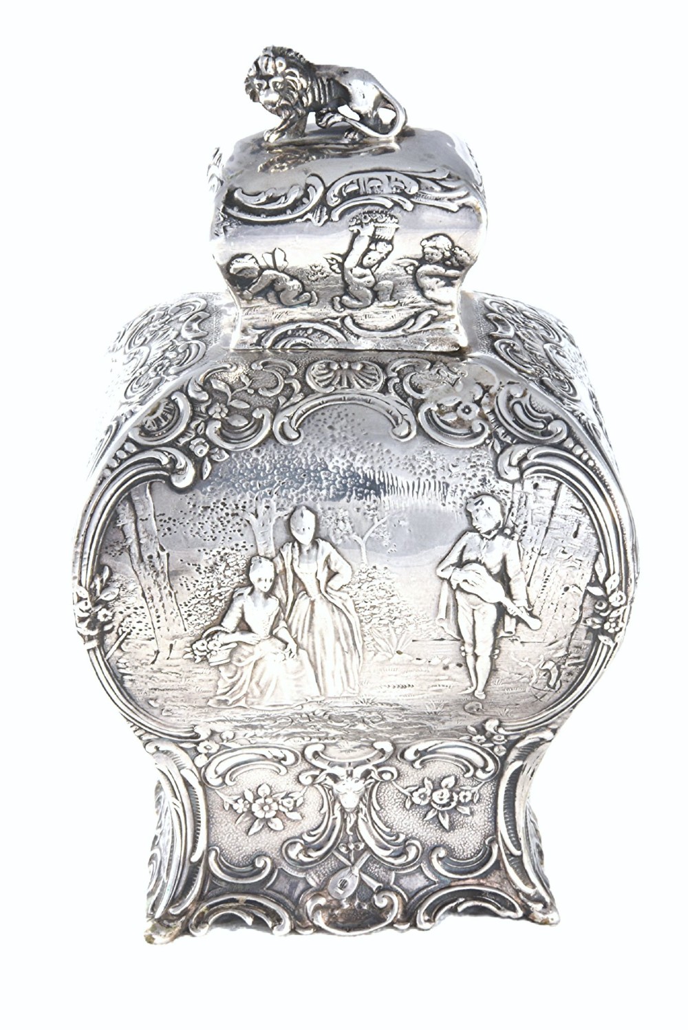 A Victorian sterling silver tea caddy featuring a shaped bombe body with detailed repousse pastoral scenes and a lion finial on the lid. View II