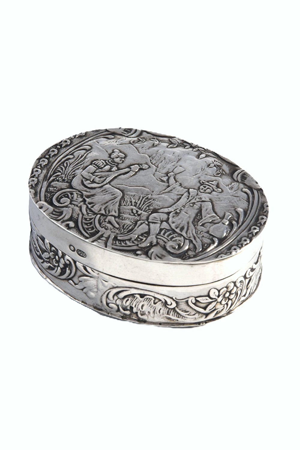 An oval sterling silver Edwardian snuff box with a relief scene on the hinged lid and floral scrollwork around the sides.