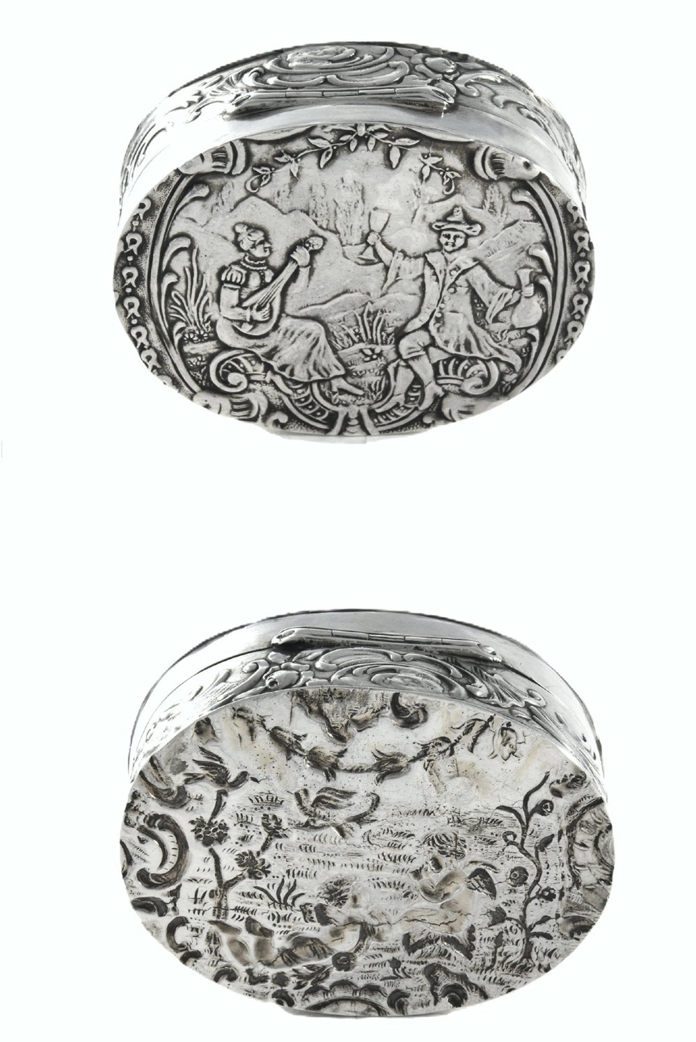 An oval sterling silver Edwardian snuff box with a relief scene on the hinged lid and floral scrollwork around the sides. View II