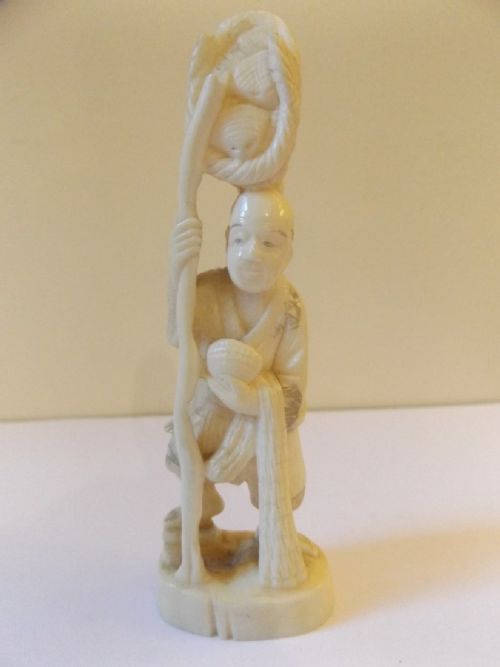 Japanese Ivory Okimono of a Man Carrying Baskets C1900