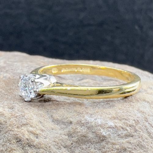 fig 1. An 18ct yellow gold ring featuring a single round brilliant-cut diamond held in a claw setting.