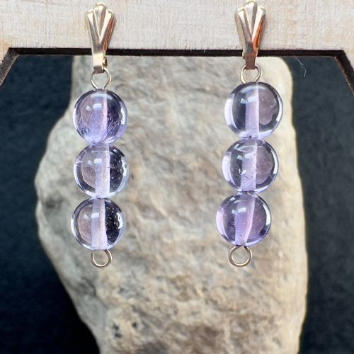 fig 1. A pair of 9ct gold drop earrings featuring three polished spherical purple amethyst beads suspended vertically from gold bails.